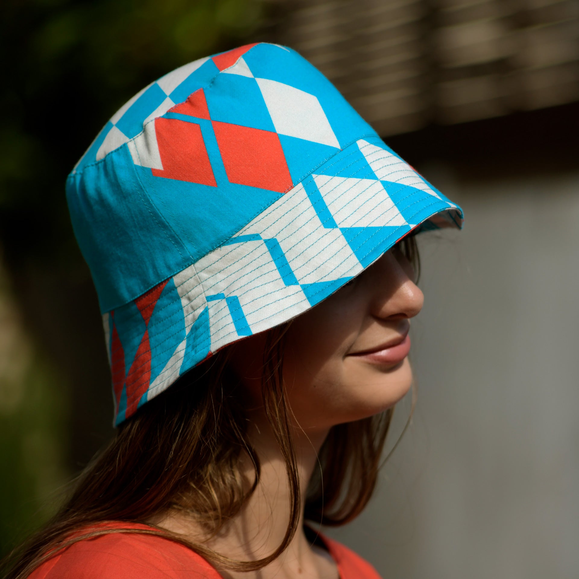 Young woman with the Kristina Nordöf bucket hat in turquoise, beige, raspberry red